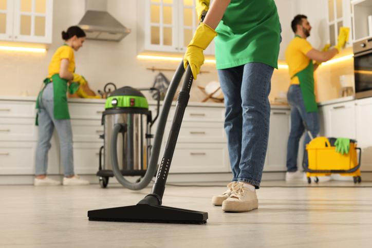 The group of professional cleaners is performing post-renovation cleaning together.