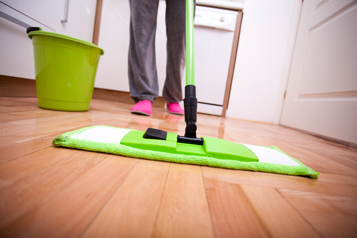 A man is mopping to demonstrate how to clean commercial floors.