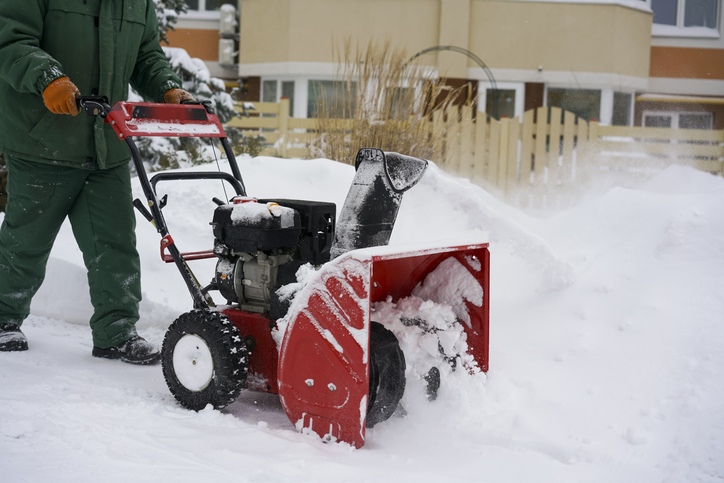 A professional cleaner provides commercial snow removal services to clear pathways, helping to avoid slippery walkways and potential accidents.